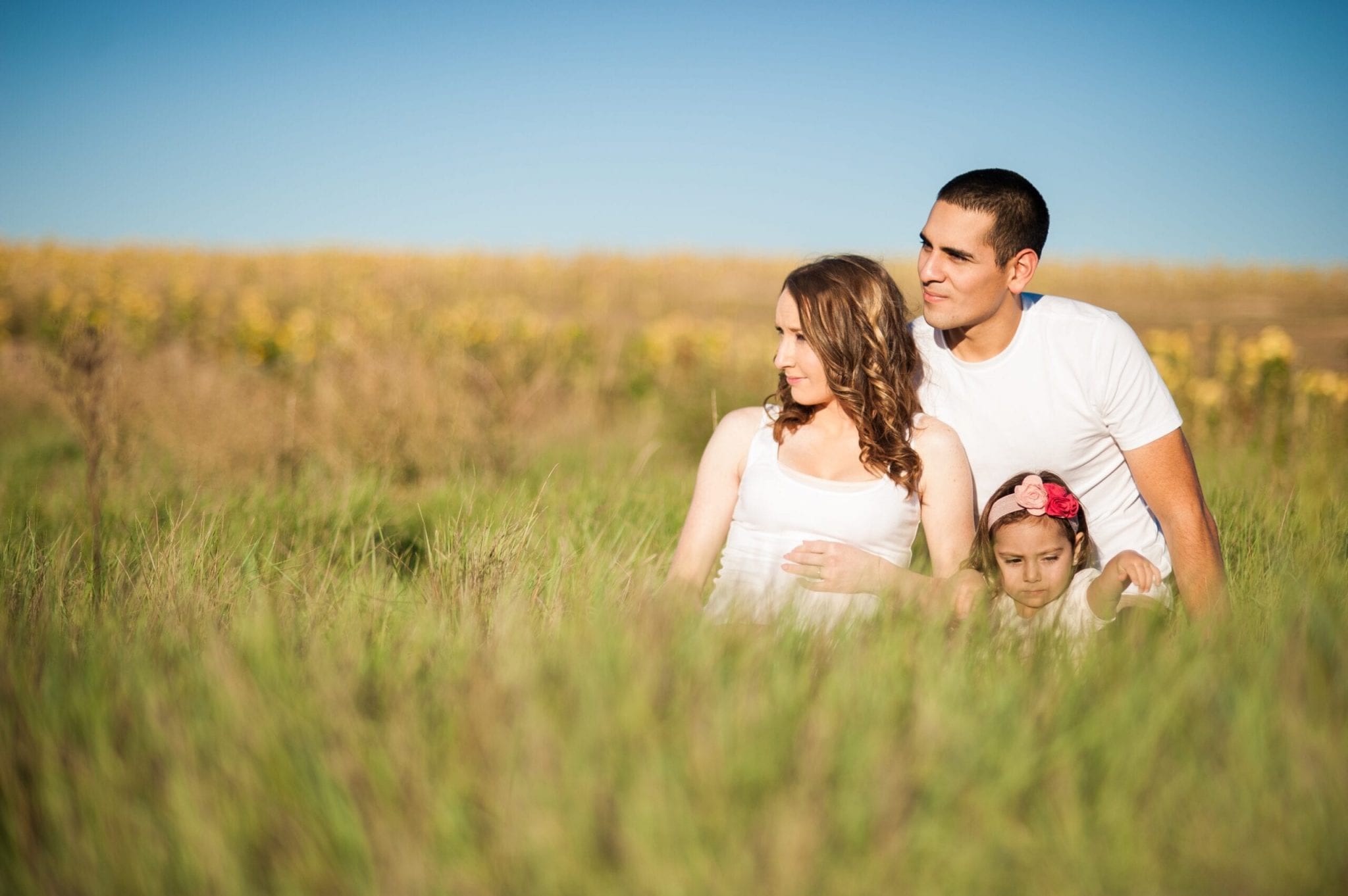 family sitting in a meadow